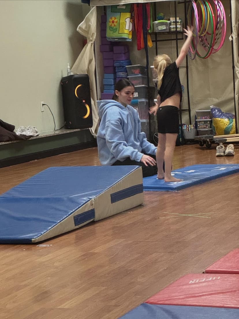 Instructor working with a young dancer on movement skills